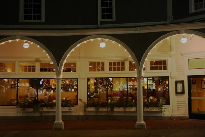 Siena's arched entrance at Mashpee Commons, lit up in the evening